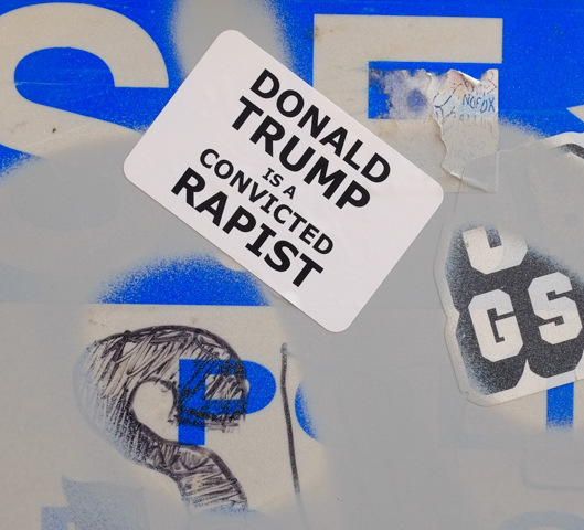 sticker graffiti that is words that say Donald Trump is a racist