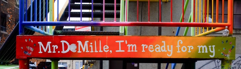 text painted on metal stairs in an alley that says Mr. De Mille, I'm ready