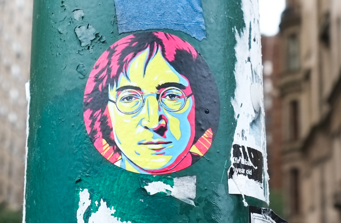 paste up graffiti on a green pole, portrait of John Lennon