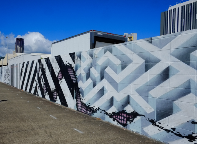 street art paintings on a concrete wall, part is a 3 dimensional looking maze