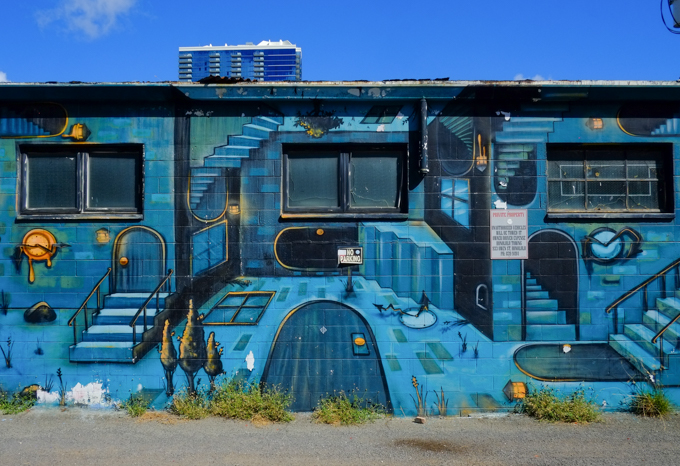 three real windows surrounded by a mural by katch 1 that has drk arched spaces