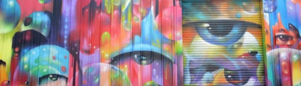 eyes among many runny colours, in a mural by vyal reyes in the container yard at arts district in LA