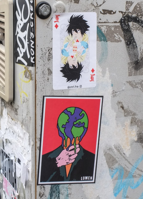 2 poster sized paper graffiti paste ups on a wall in naples, bottom is by lumen, a person with a globe of the Earth for a head