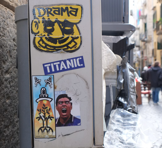 Naples slaps , drama on a yellow face, the word titanic, a man yelling and a tree under a spotlight with words garde vs stelleconfuse