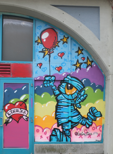 street art mural in Lynn Mass USA, grimly toys, red balloon, character wrapped up in cloth like a mummy