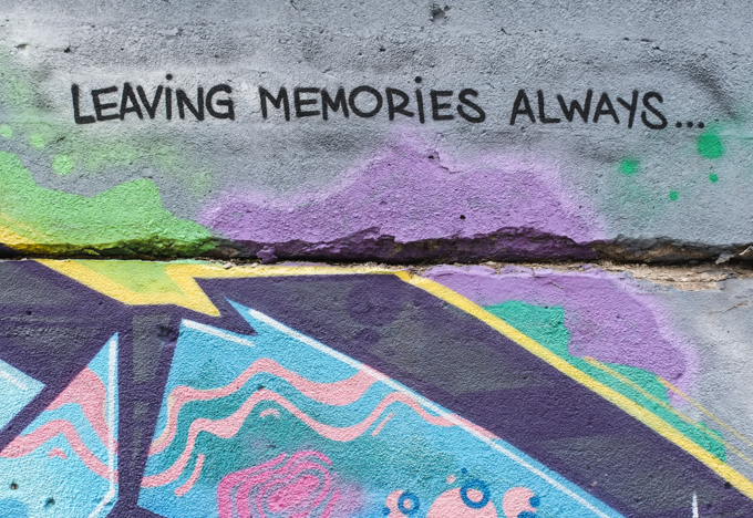the words leaving memories always written in black capital letters on a wall with other street art colours