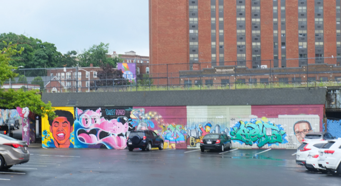 a row of street art murals under a railway line