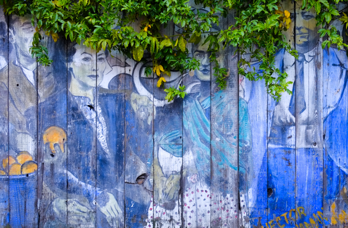 faded blue mural of people standing together 