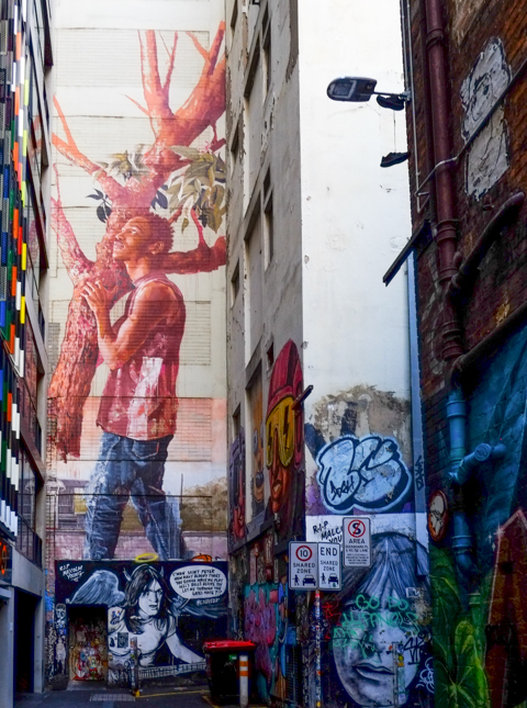 street art in ACDC lane, central Melbourne, mural by Fintan Magee of a man carrying a tree, 