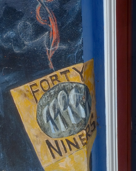 part of mural, Forty niners poster in window