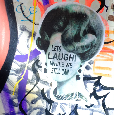 urban art in AC DC lane in Melbourne, with text that says Lets laugh while we still can, written on woman's face,  by Jover