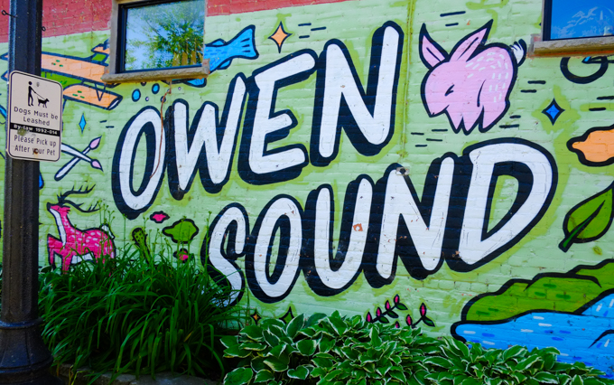 street art mural with words, Owen Sound, and a pink bunny and a blue fish