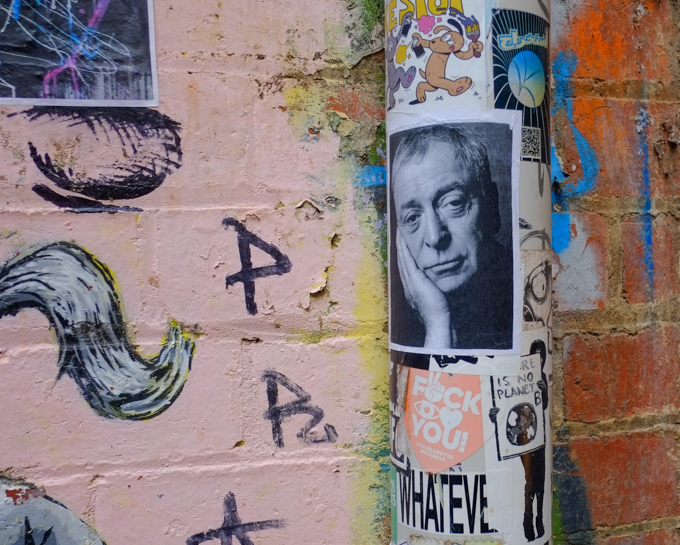 portrait of Michael Caine, black and white photo, on poster, as a paste up in AC DC lane. 