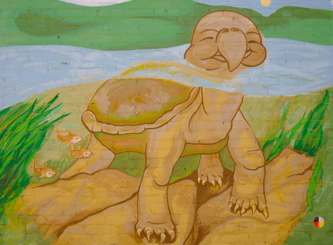 brown turtle partially submerged in water, face is above water street art painting