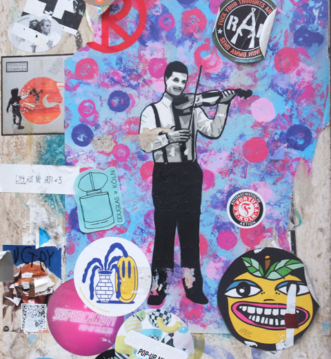 slaps and paste ups on a wall, a man in black pants and white shirt, playing a violin. sticker by nanE, another sticker by zoologne, 