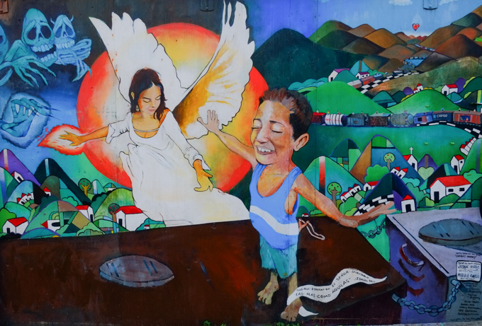 mural by Josue Rojas in Balmy Alley San Francisco, angel, young boy with arms outstretched as if flying