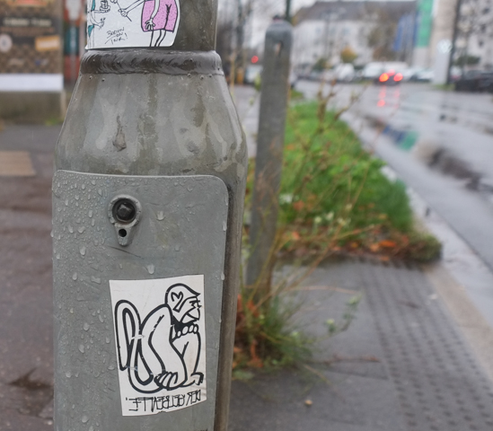 a monkey sticker on a grey metal pole