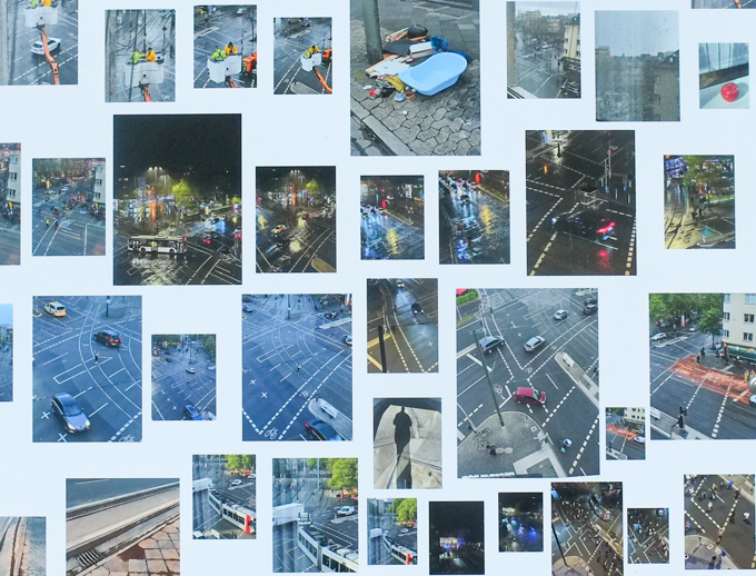 close up of part of one panel, many coloured photos mounted on large white sheets of paper or bristol board, and then mounted on plywood, displayed outside