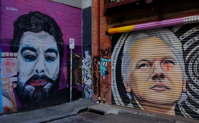 muralsin an alley, On the right, Julian Assange, of WikiLeaks fame, is painted on a roller door. On the left is a portrait of a different man, Ethan Joker, by Lushsux
