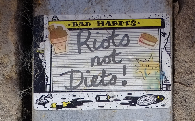 sticker graffiti, with text bad habits, plus cursive writing riots not diets