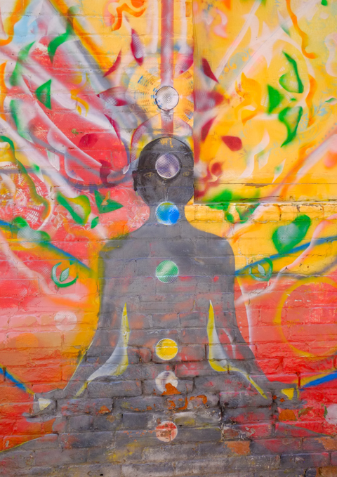 person in yoga position, mural on outside wall in alley