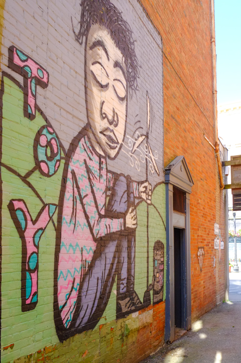 mural of a boy sitting on the floor in Artist's Alley in Owen Sound
