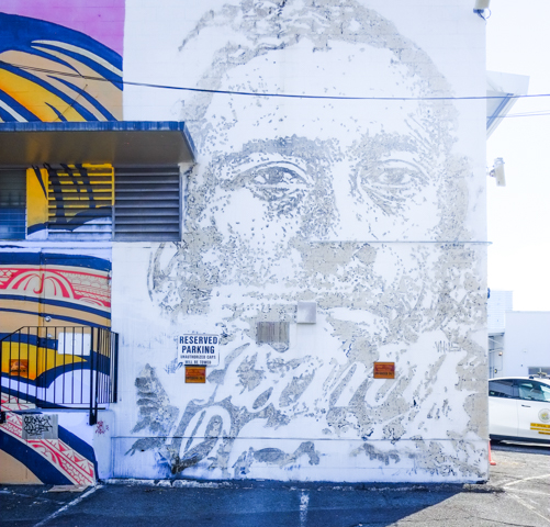 portrait of a man, by Vhils, picture made by chipping away at the concrete to reveal different layers with different shades of grey