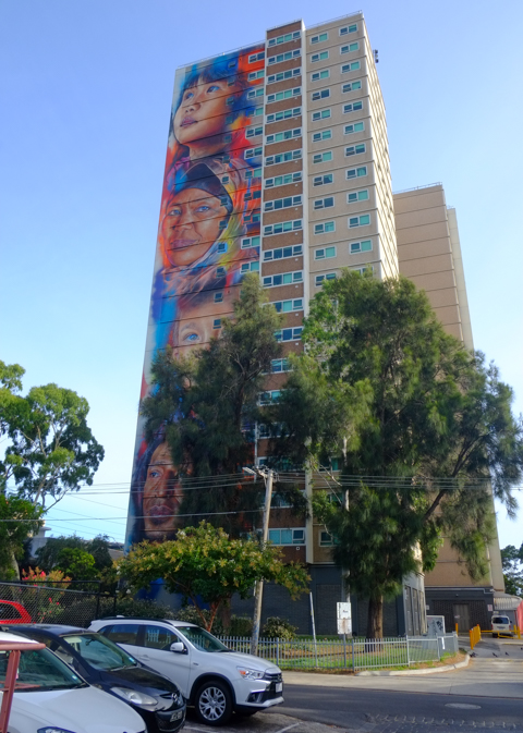 tall apartment building in Collingwood, Melbourne, with 4 large portraits by adnate down the side of one wall