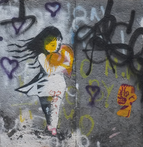 stencil of a young girl carrying a large heart