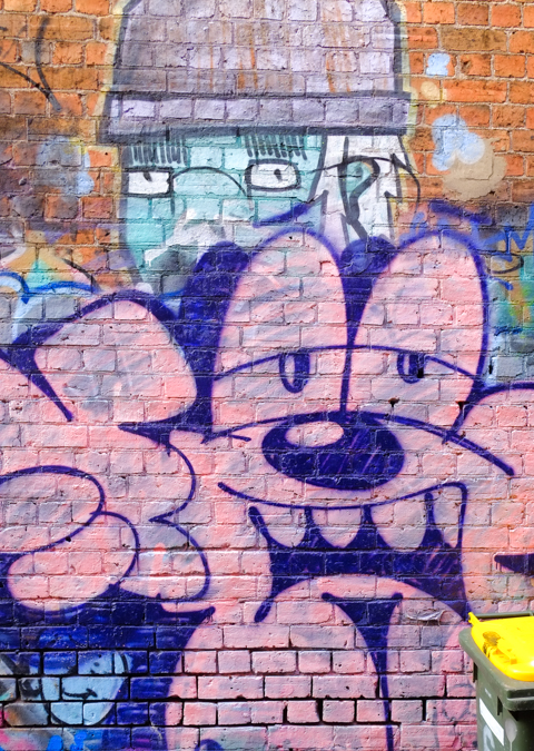 painting of person in rounded hat, with comic character like tag in front