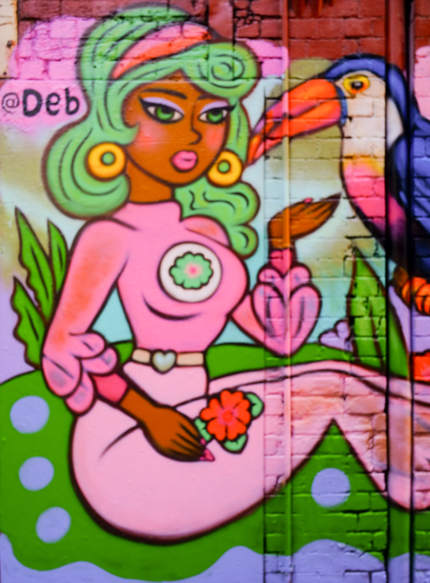 mural by deb, woman and a parrot or toucan