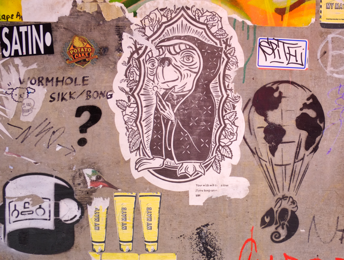 graffiti in Rankins Lane, Melbourne, paste ups and stencils, globe parachute on an iguana, ET in a black robe and framed with flowers, words that say your dreams will come true if you keep wishing, and last, a big black question mark, 