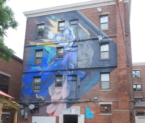 large mural on the side of a brick residence by Felipe Ortiz and Ivan Salazar
