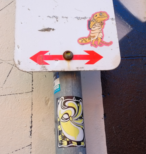 graffiti stickers on a street sign