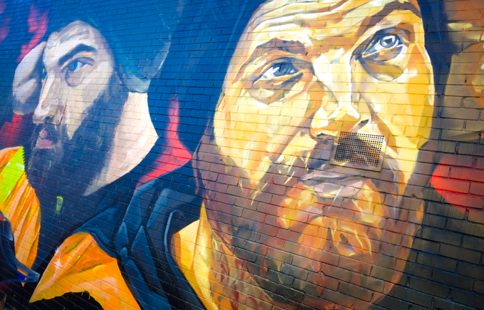 street art painting, portrait, 2 workman with beards and mustaches, yellow and orange high viz vests, black wool hats