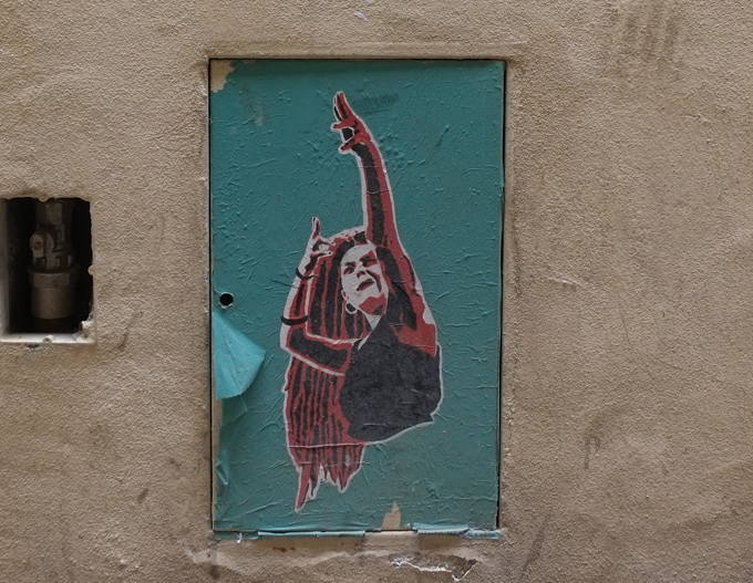paste up graffiti, woman with arm in air