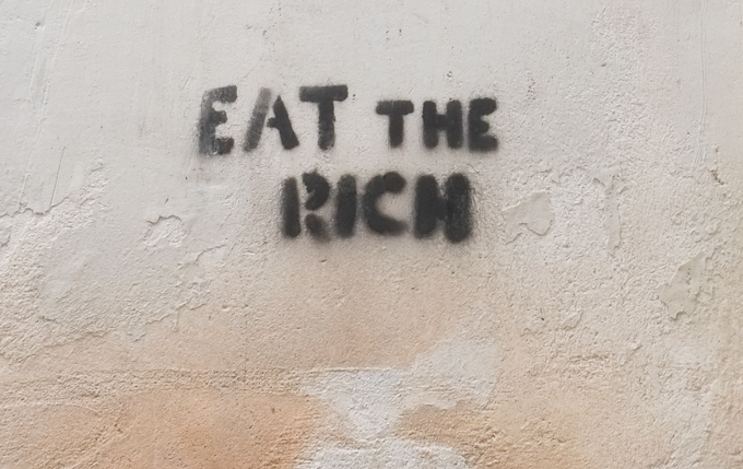 stencil graffiti in Palermo, text that says eat the rich