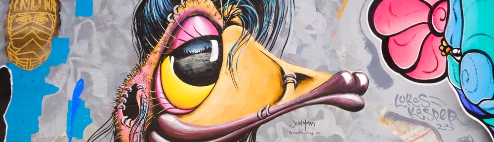 part of a street art mural featuring a crazy punk eu with blue, and many piercings