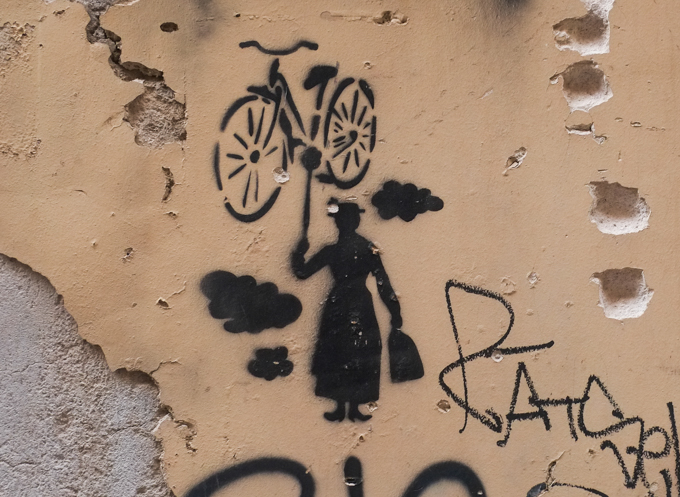 stencil graffiti in Palermo, Mary Poppins holding up a bicycle instead of an umbrella