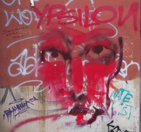 black line drawing of a face, with minimal lines, with lots of red around the lines