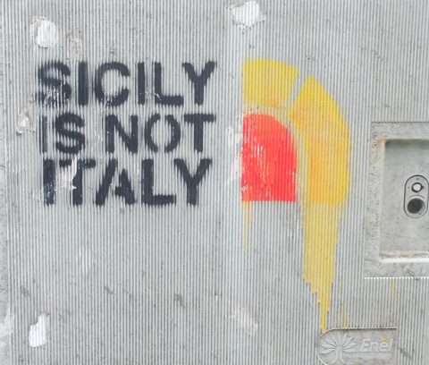 stencil graffiti in Palermo, text that says Sicily is not Italy