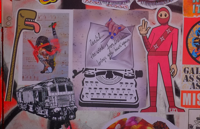 graffiti paste ups and stickers on a wall