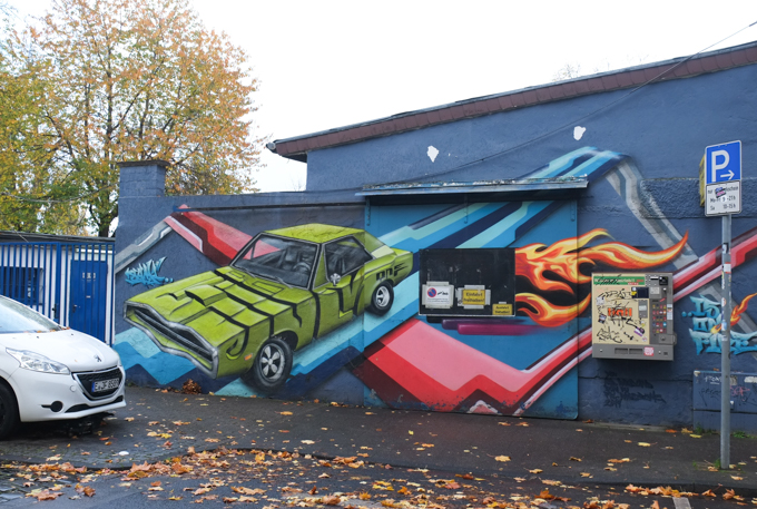 mural of a car crashing through the wall of a building