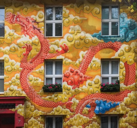 mural on front of apartment block on kiefernstrasse, walls have red dragon with gold clouds, 