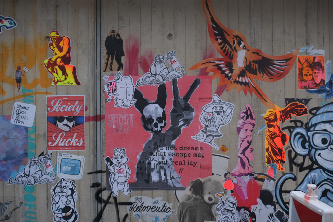 collection of graffiti and urban art on a concrete wall in Bonn