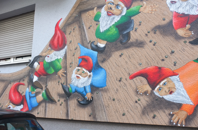 little gnomes in pointy red caps in a mural