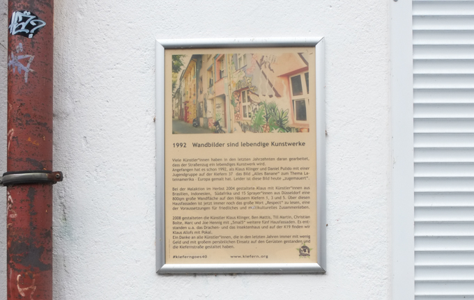 framed picture of an article about the history of Kiefernstrasse, 1992, the year the first mural was painted here