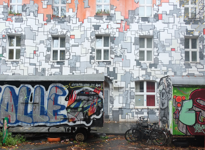 large image of the urban art mural, monochrome mural that is part puzzle pieces and part little figures. Ben Mathis was responsible for creating the 'grid', while MaJo Brothers painted the figures such as this robot holding a cracked egg