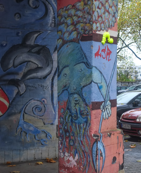 urban art painting of neptune, the god, upside down, with trident in his hand, a dolphin swims nearby