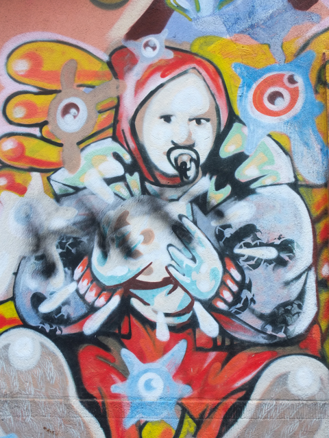 part of larger mural, person with a red hat and a pacifier in his or her mouth
